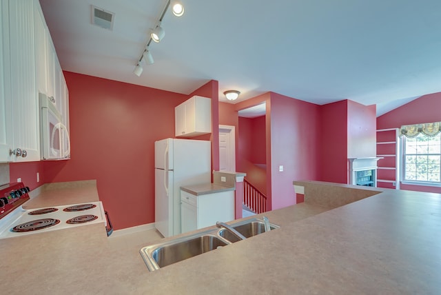 kitchen featuring white cabinets, sink, white appliances, rail lighting, and vaulted ceiling