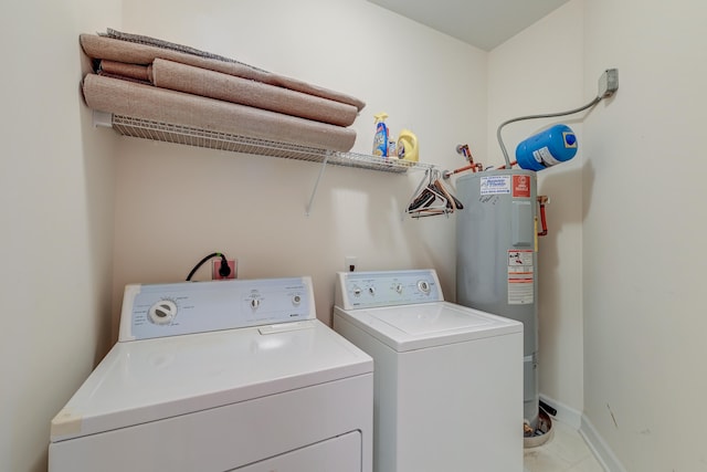 washroom with gas water heater and washer and dryer