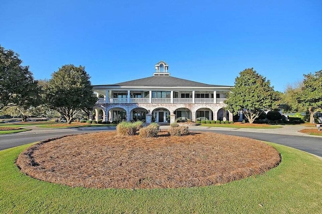 view of front facade featuring a balcony and a front lawn