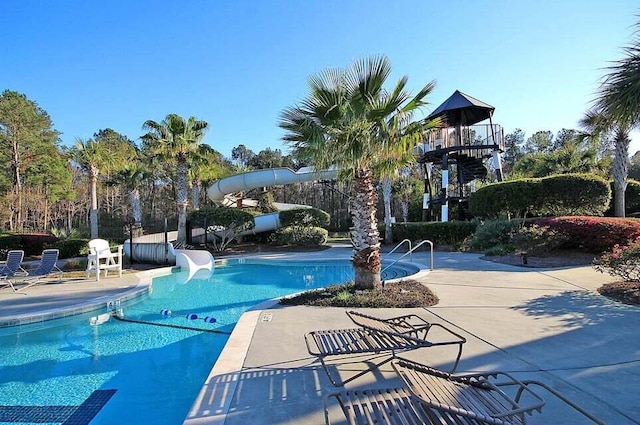 view of swimming pool featuring a water slide and a patio area