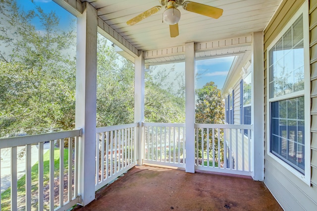 unfurnished sunroom featuring ceiling fan and a wealth of natural light