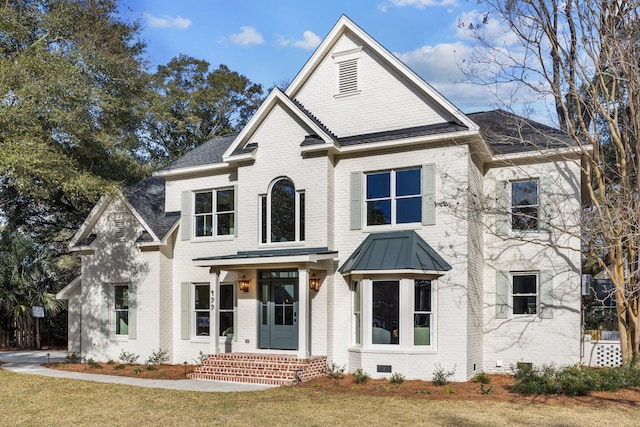 view of front of home with crawl space, a standing seam roof, a front lawn, and brick siding