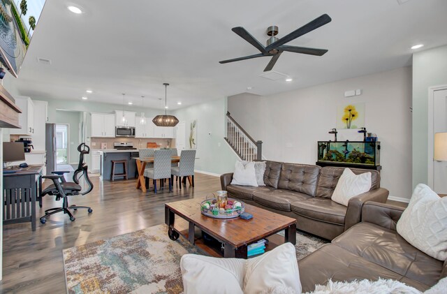 living room with light wood-type flooring and ceiling fan