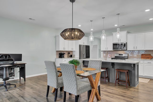 dining space featuring light wood-type flooring and sink