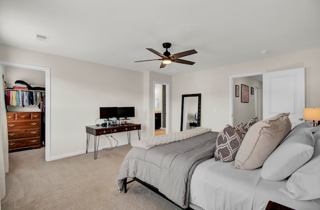 carpeted bedroom with ceiling fan, a closet, and a spacious closet