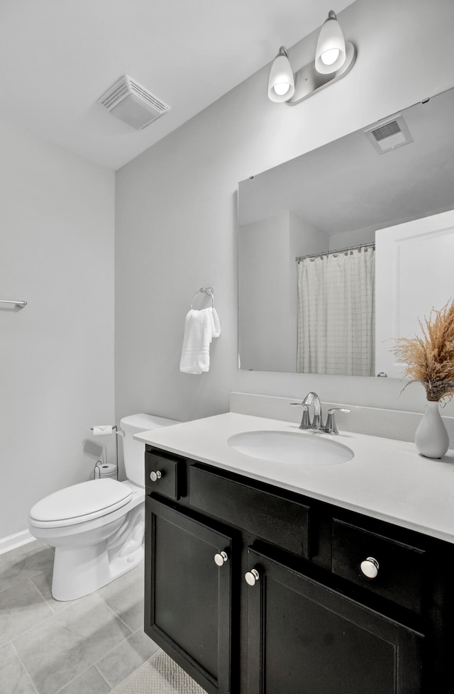 bathroom featuring tile patterned floors, vanity, and toilet