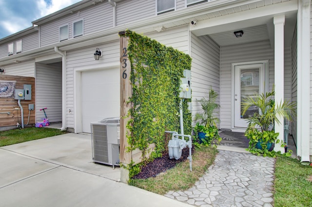 entrance to property with a garage and central AC unit