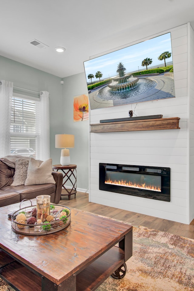 living room with wood-type flooring and a fireplace