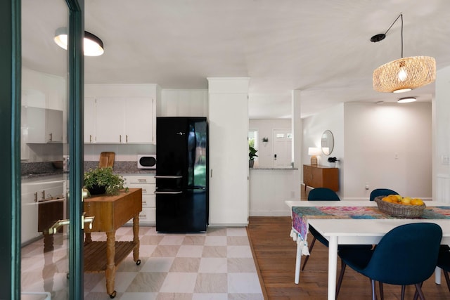 1417 Downing St, Charleston, SC 29407 - kitchen featuring freestanding refrigerator, white microwave, white cabinetry, decorative light fixtures, and light wood finished floors