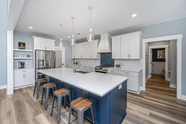 kitchen with custom exhaust hood, a sink, appliances with stainless steel finishes, baseboards, and recessed lighting