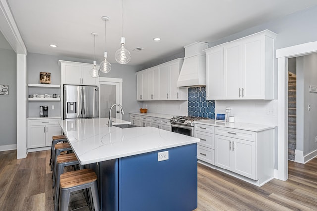 kitchen with stainless steel appliances, a sink, custom exhaust hood, open shelves, and recessed lighting
