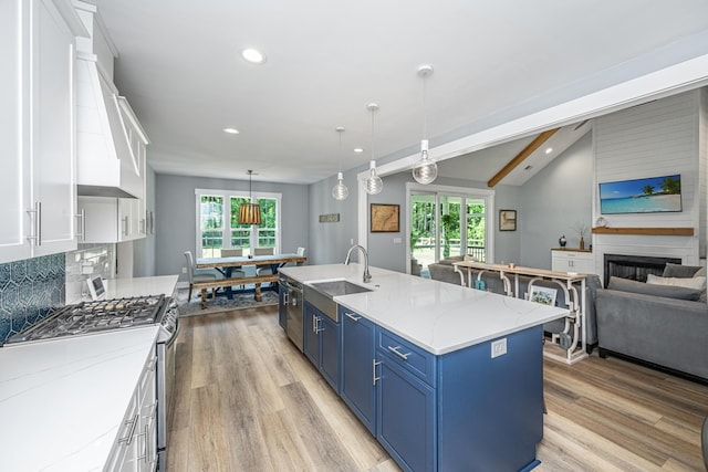 kitchen featuring a sink, blue cabinets, appliances with stainless steel finishes, white cabinets, and light wood-style floors