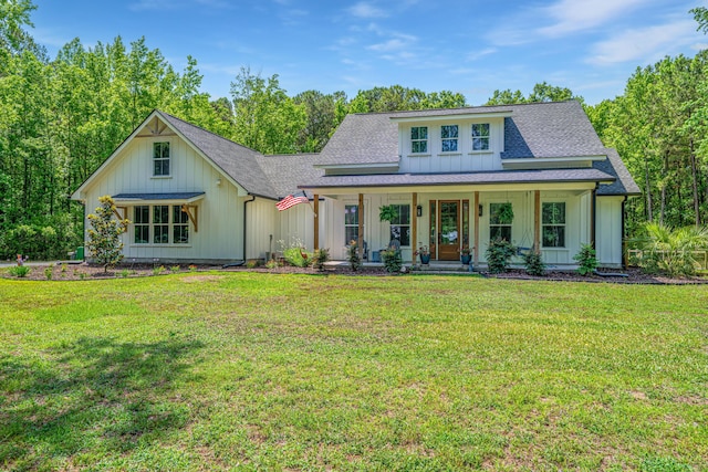 modern farmhouse featuring covered porch, a shingled roof, board and batten siding, and a front lawn
