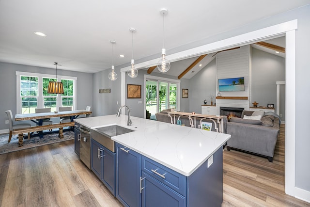 kitchen with a sink, blue cabinetry, light wood-type flooring, recessed lighting, and a kitchen island with sink