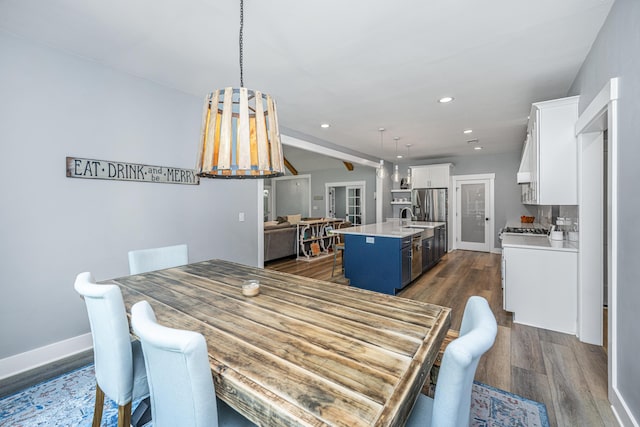 dining area featuring dark wood-type flooring, recessed lighting, baseboards, and beam ceiling