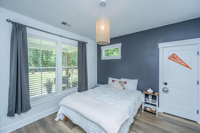bedroom with wood finished floors and baseboards