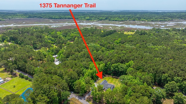 aerial view of property and surrounding area with a heavily wooded area and a large body of water