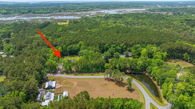 aerial view of property's location with a forest and a nearby body of water