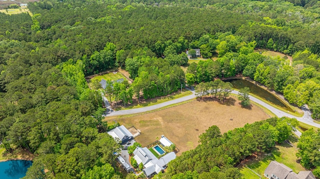 aerial view of property and surrounding area with a forest and a large body of water