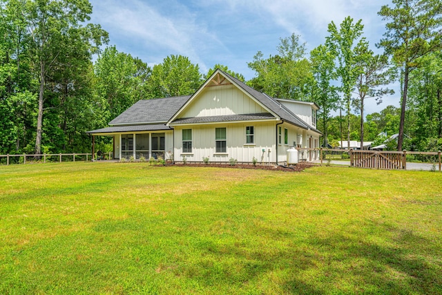 rear view of house with a sunroom and board and batten siding