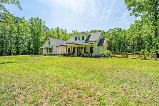 rear view of property with board and batten siding, covered porch, and a shingled roof