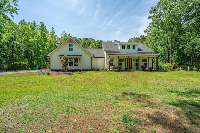view of front of property with a porch, a front yard, roof with shingles, and board and batten siding