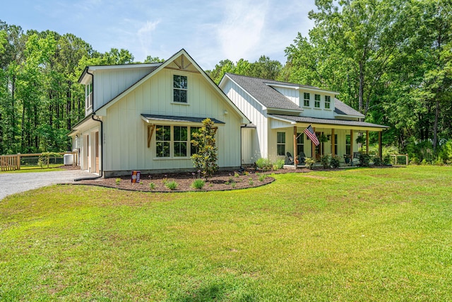 modern farmhouse style home with gravel driveway, covered porch, a front yard, a garage, and board and batten siding