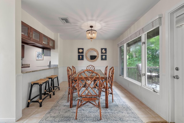 dining area with light tile patterned floors and an inviting chandelier