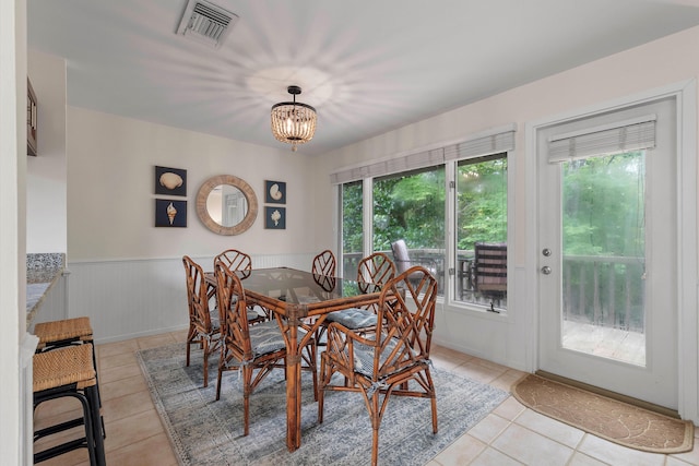 dining space featuring a notable chandelier, light tile patterned flooring, and a healthy amount of sunlight