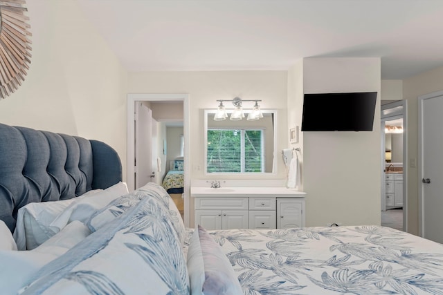 bedroom with ensuite bath, sink, and carpet flooring