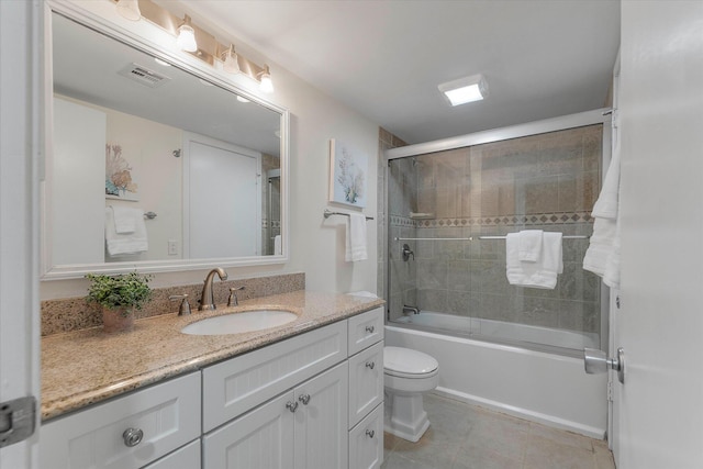 full bathroom featuring toilet, bath / shower combo with glass door, vanity, and tile patterned flooring