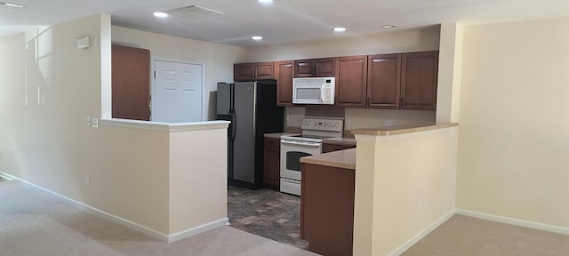 kitchen with white appliances, kitchen peninsula, and carpet floors