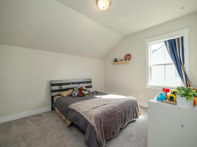 bedroom featuring light colored carpet and vaulted ceiling