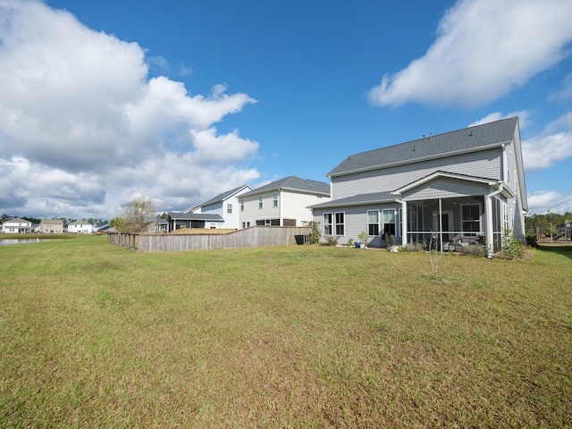 back of property featuring a lawn and a sunroom