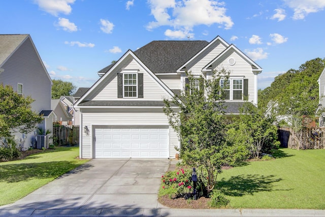 traditional-style house with central air condition unit, concrete driveway, an attached garage, a shingled roof, and a front yard