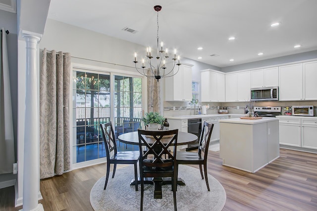 dining area featuring a toaster, visible vents, recessed lighting, a notable chandelier, and wood finished floors