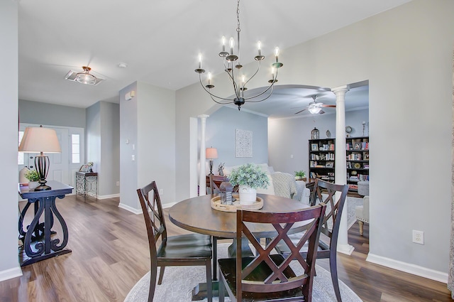 dining space with ceiling fan with notable chandelier, baseboards, decorative columns, and wood finished floors