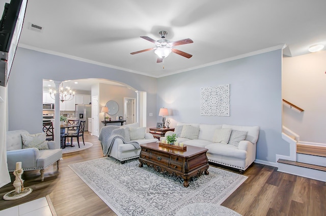 living room featuring arched walkways, a ceiling fan, wood finished floors, and visible vents