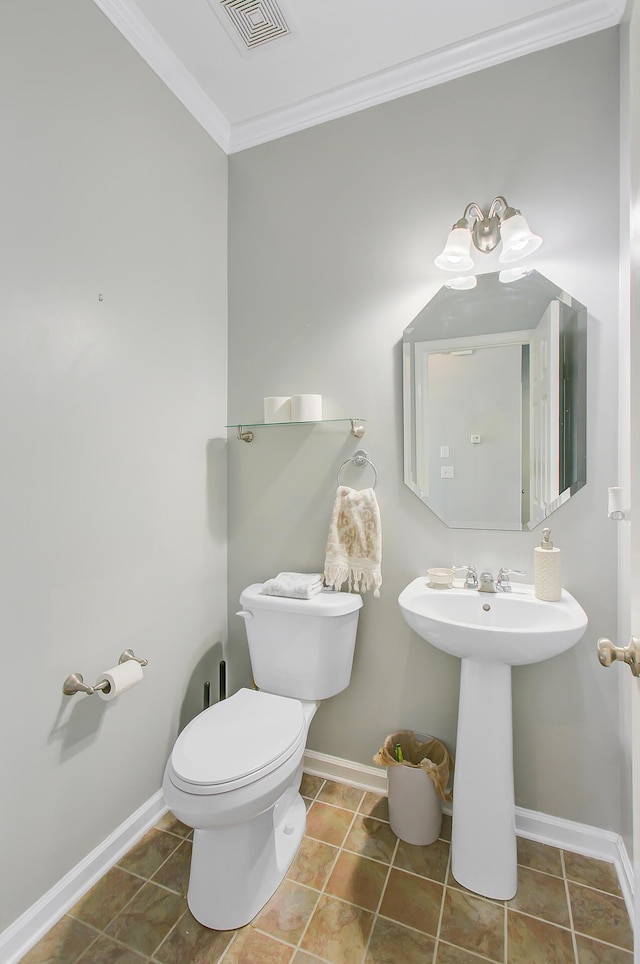 half bathroom with crown molding, a sink, baseboards, toilet, and visible vents