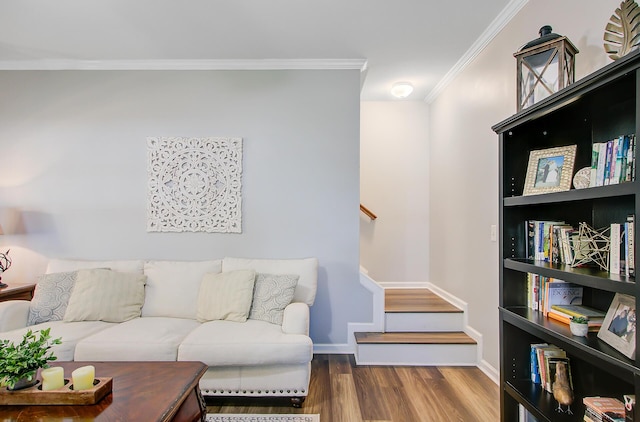 living room featuring baseboards, wood finished floors, stairs, and crown molding