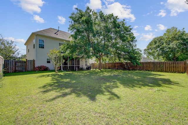 view of yard with a fenced backyard and a sunroom