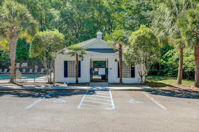 exterior space featuring uncovered parking, a community pool, and fence