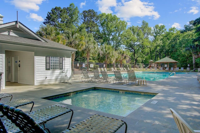 pool featuring fence and a patio area
