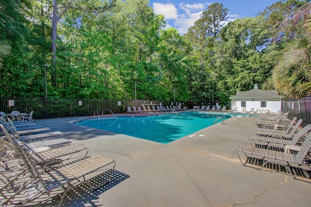 community pool featuring fence and a patio
