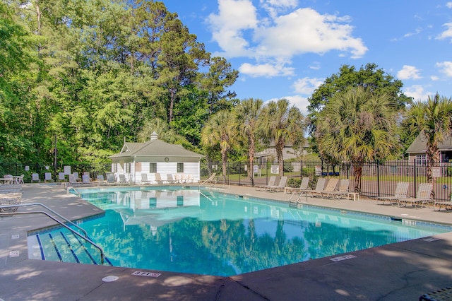 community pool featuring fence and a patio area