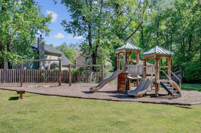 community play area featuring a lawn and fence