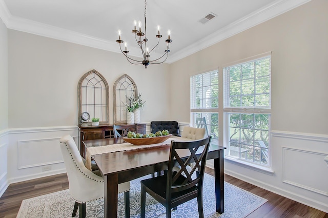 dining room featuring a wealth of natural light, dark wood-style floors, ornamental molding, and an inviting chandelier