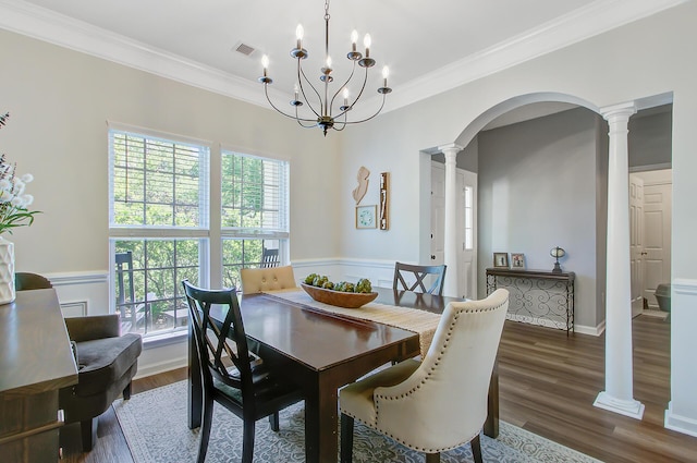 dining space featuring crown molding, decorative columns, arched walkways, and a healthy amount of sunlight