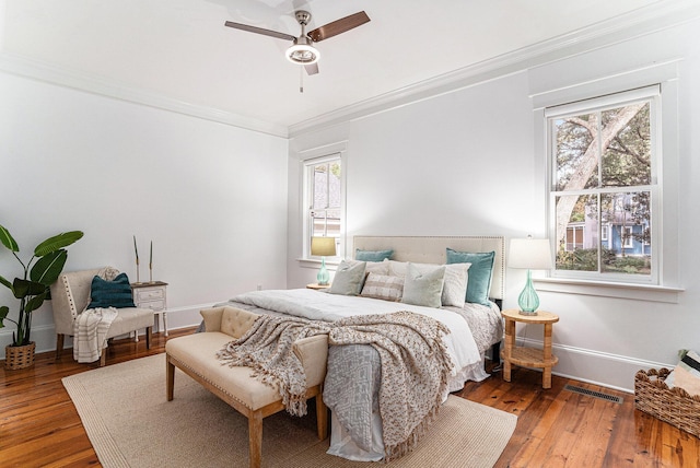 bedroom featuring ceiling fan, wood-type flooring, and ornamental molding