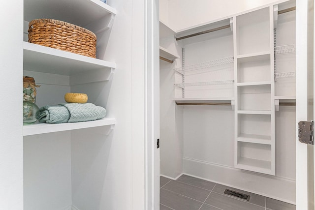 spacious closet featuring dark tile patterned flooring